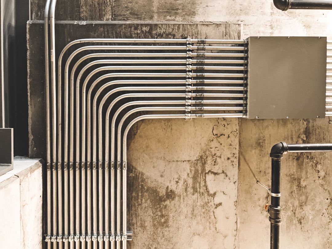 grey-metal-pipe-on-brown-concrete-wall-rvrvr9vuioq